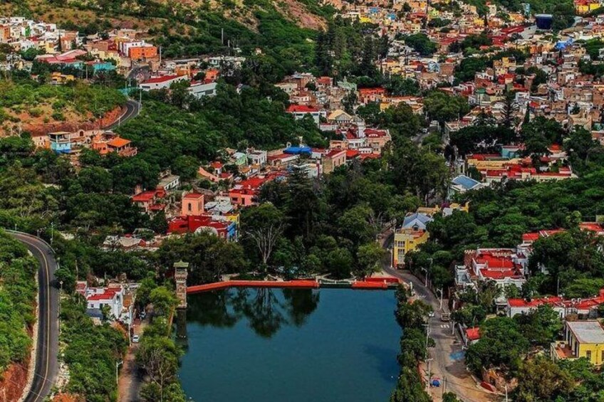 A densely populated hillside town with a prominent lake and a bridge. 3