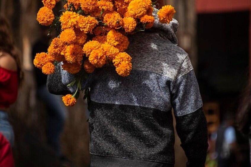 A person carrying a bouquet of marigold flowers. 1