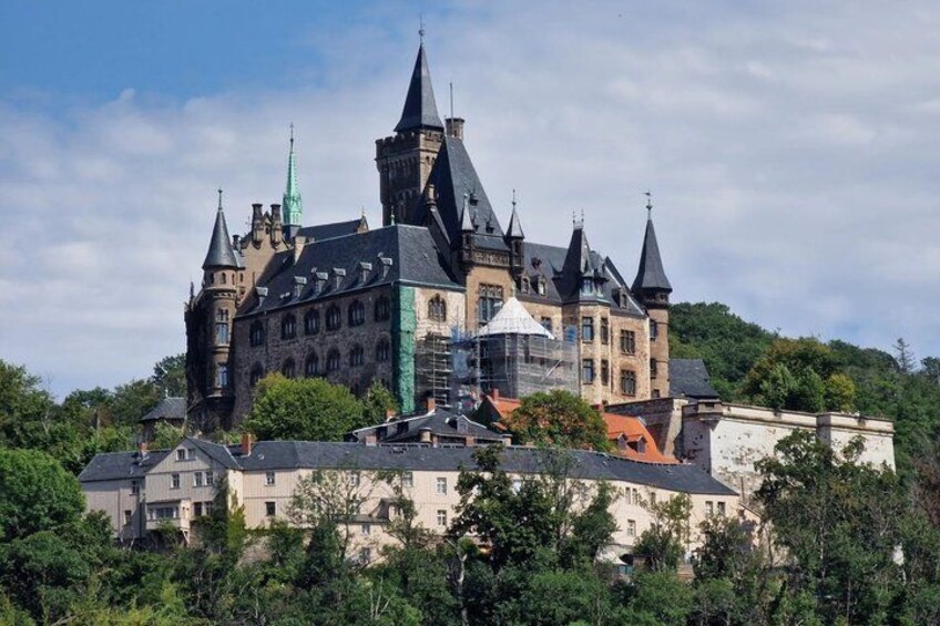 A historic castle with multiple towers, surrounded by lush greenery. 4