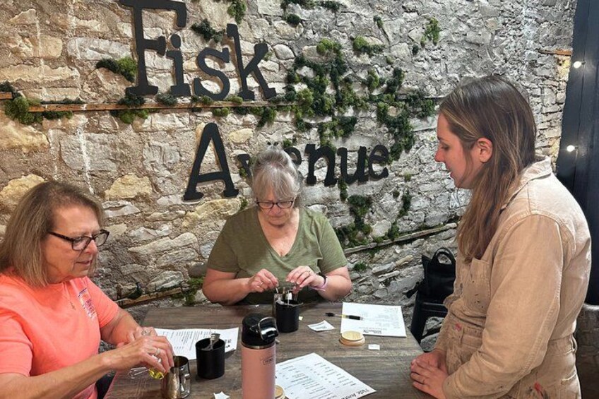 Three people at a table with a stone wall background and a sign that reads 'Fisk & Arches.' 5
