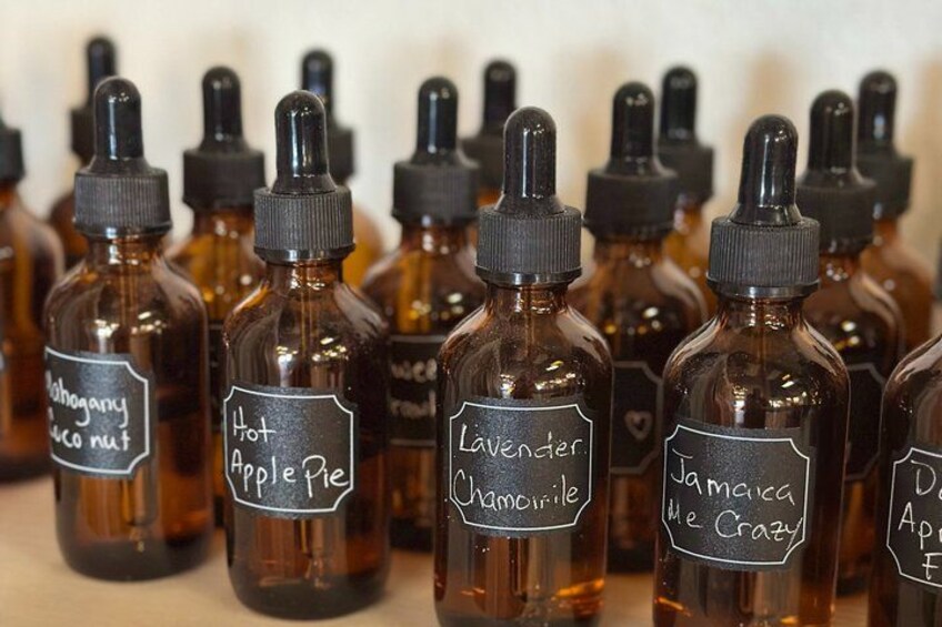 Multiple small glass bottles with labels, some with handwritten text. 4