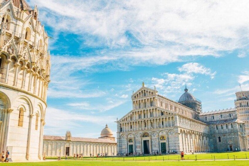 A historic building with intricate architecture, a large dome, and a well-maintained lawn. 3