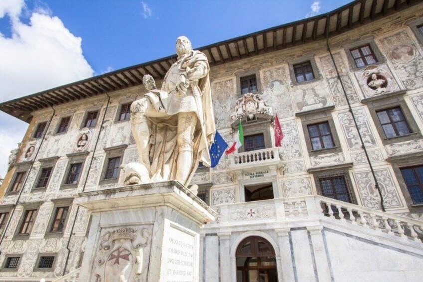 A building with a statue, flags, and intricate architectural details. 4