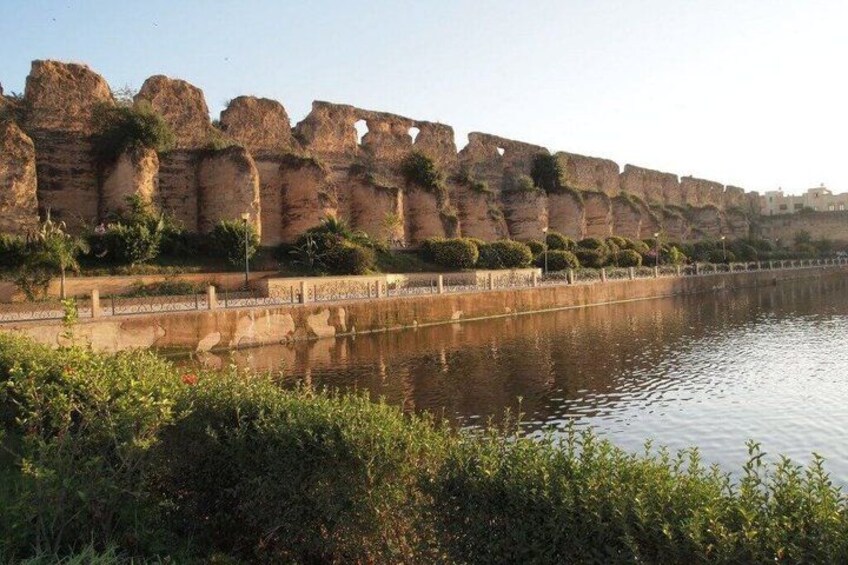 A river with a stone wall and vegetation along the banks. 3