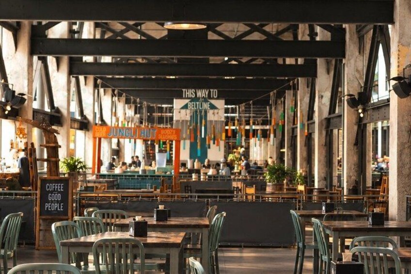 An indoor cafe with wooden tables and chairs, a bar area, and hanging decorations. 4