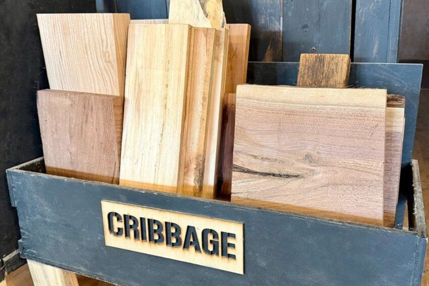 A wooden box labeled 'CRIBBAGE' filled with various types of wood planks. 2