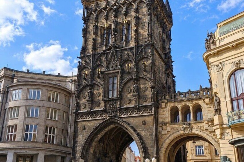 A historic building with intricate Gothic architecture, featuring a prominent tower and arched entrance. 2