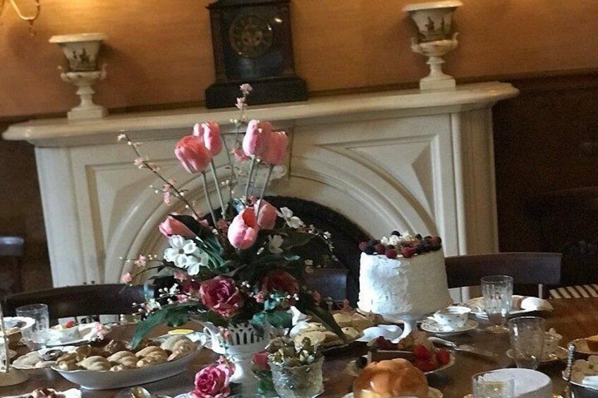 A dining table with a cake, flowers, and various dishes. 2
