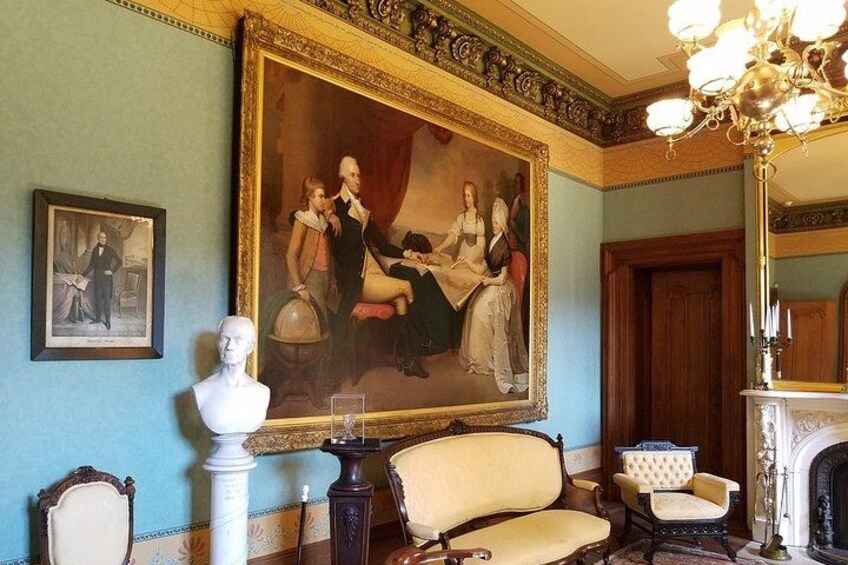 A room with a large classical painting, a bust sculpture, and ornate furniture. 5