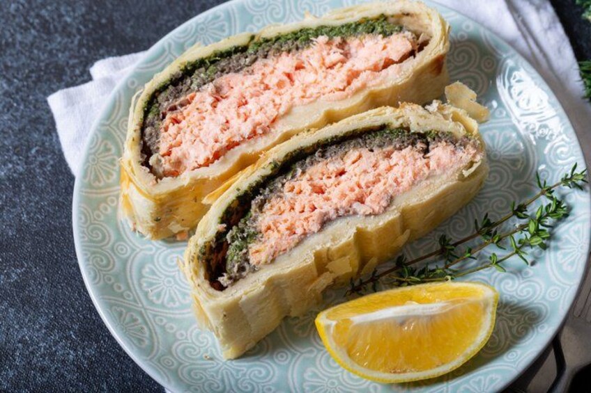 A rolled salmon dish with a slice of lemon on a patterned plate. 5