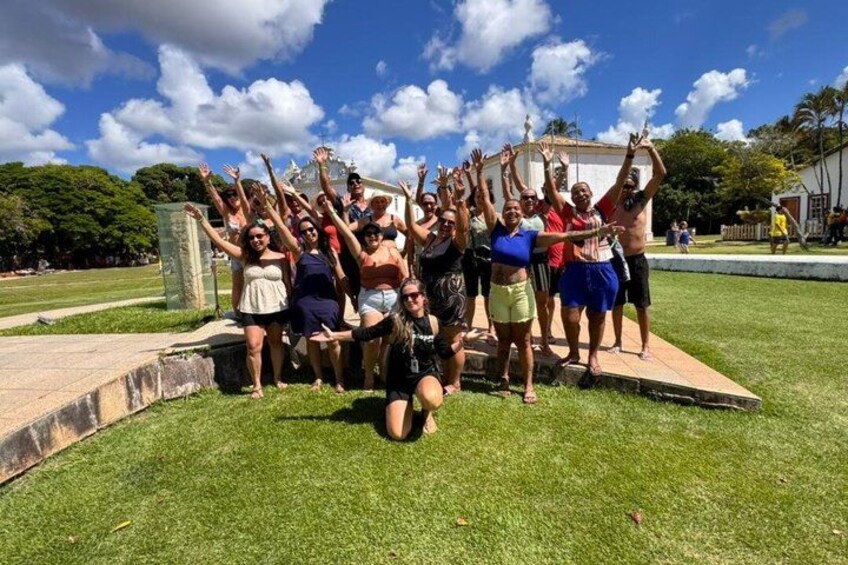 A group of people outdoors with raised hands, a grassy area, and a clear sky. 1