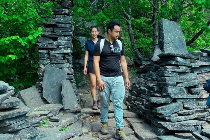 Two people walking on a stone path surrounded by greenery. 5
