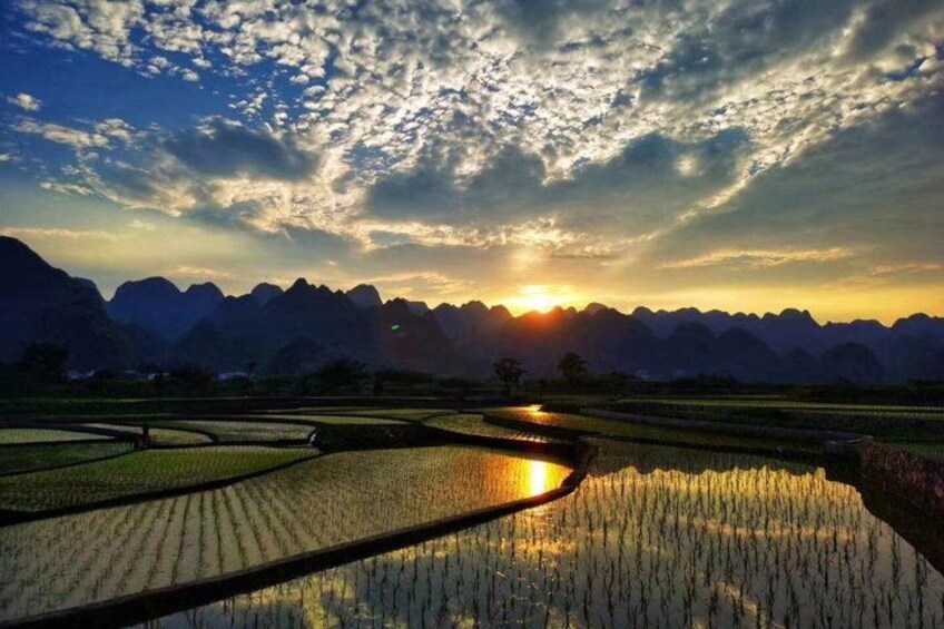 Terraced rice fields, a mountain range, and a sunset. 2