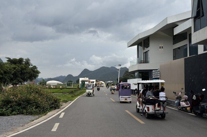 A road with vehicles, a modern building, and mountains in the background. 3