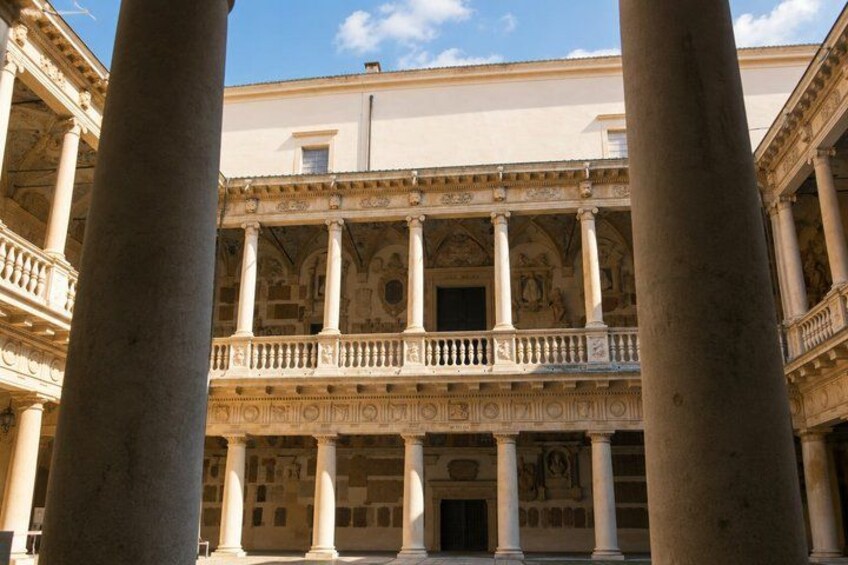 A classical building with columns and a balcony. 5