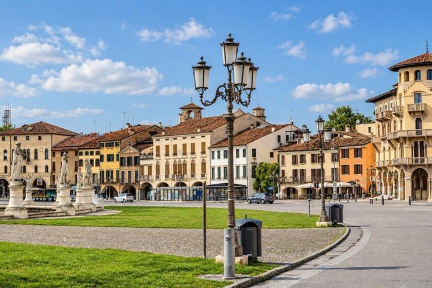 A historic square with a fountain, buildings, and a street lamp. 2