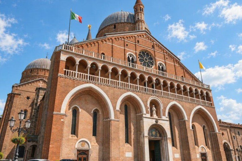 A large brick building with arched windows and a dome. 4