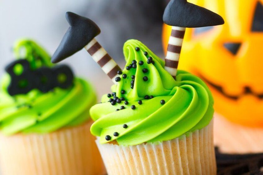 Cupcakes with green frosting and Halloween-themed decorations. 2