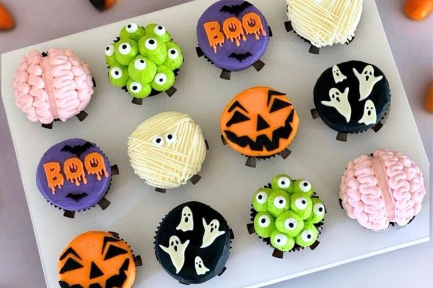 A tray of Halloween-themed cupcakes with various decorations. 5