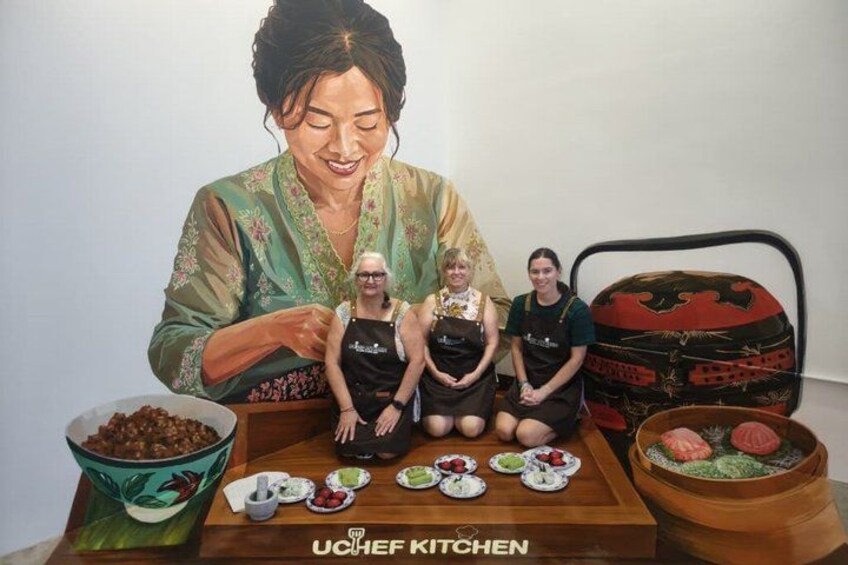 A person cooking with three others, a table with food, and a kitchen setting. 4