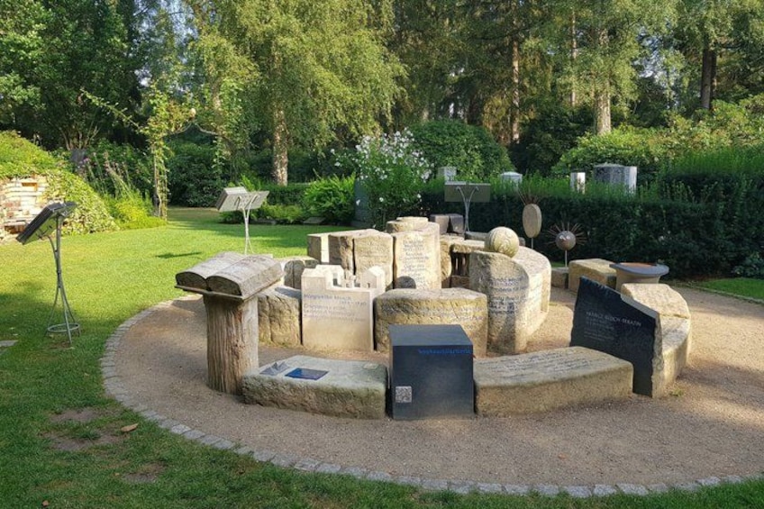 A stone monument with inscriptions in a park. 5