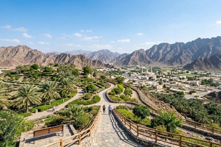 A mountainous landscape with a winding road, palm trees, and a distant town. 2