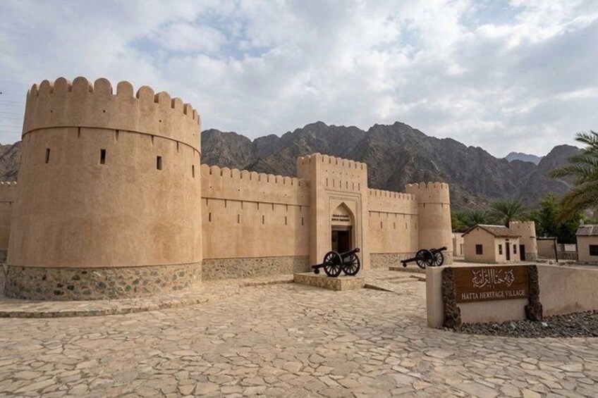 A historical fort with a round tower, a gateway, and cannons. 1