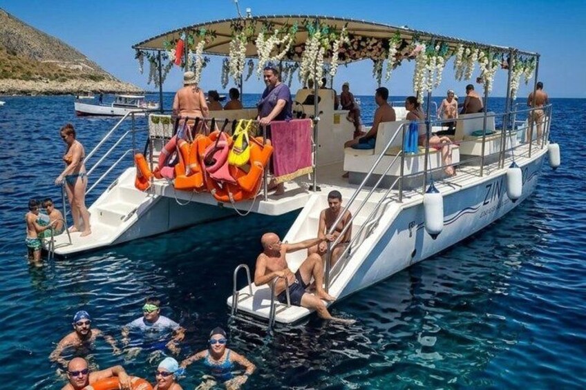 A boat with people on it, surrounded by water and a distant landmass. 3