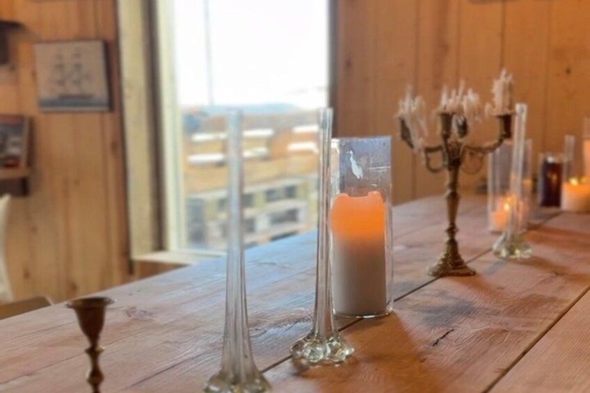 A wooden table with candle holders and a lit candle. 4