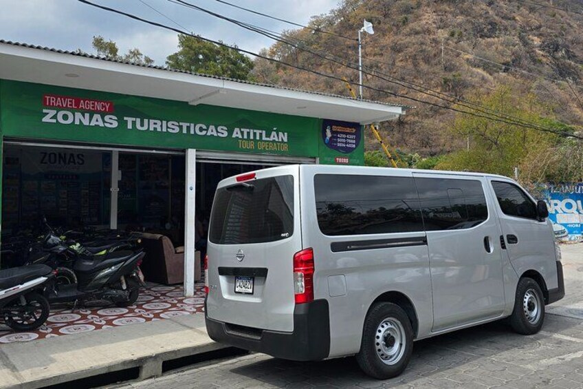 A white van parked in front of a travel agency named 'Zonas Turísticas Atitlán'. 3