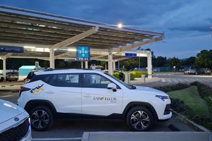 A white SUV with 'ZAP TECOS' branding parked at a gas station. 4
