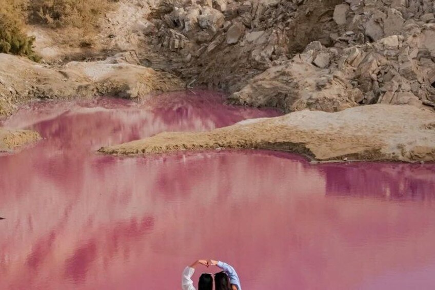 A rocky landscape with a body of water reflecting a pinkish hue. 2