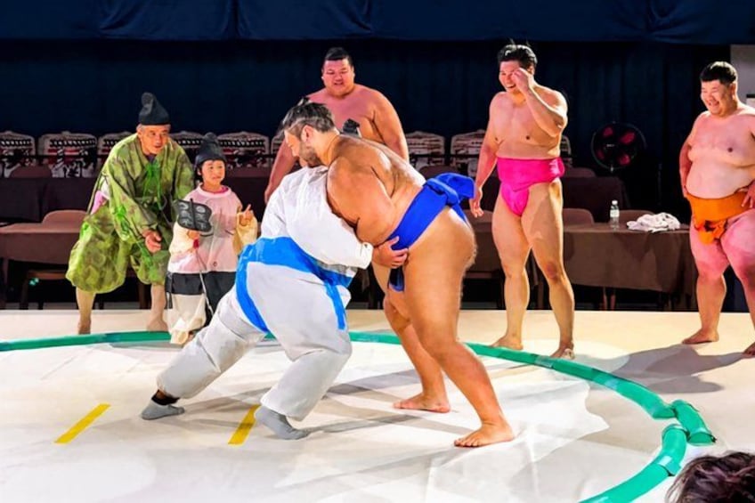 A sumo wrestling match with participants in traditional sumo attire. 2