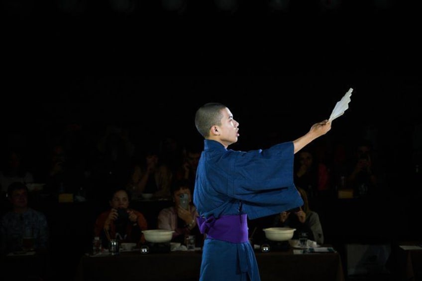 A person in a blue martial arts uniform performing a demonstration. 5