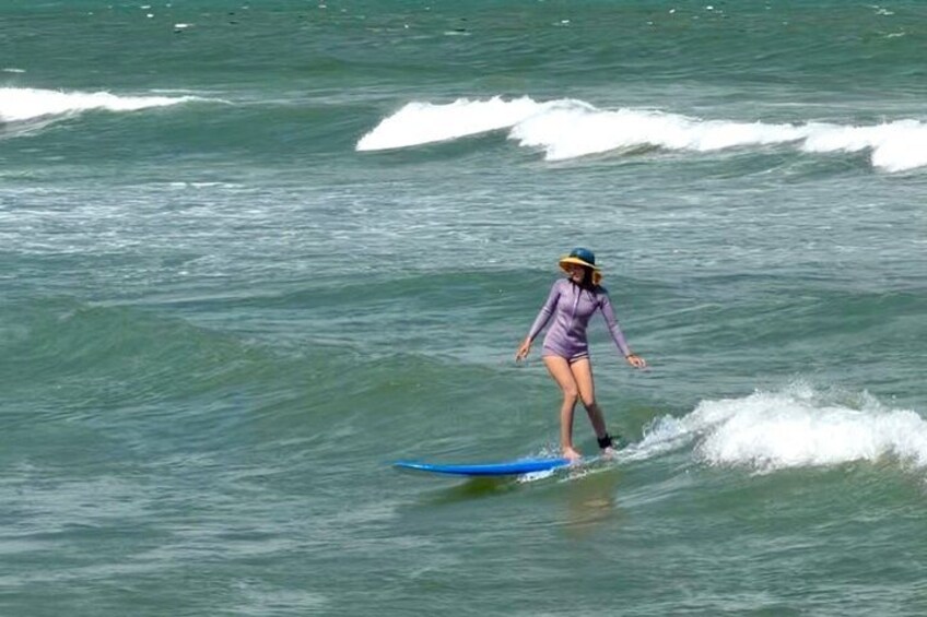 A person surfing on a blue board in the ocean. 1
