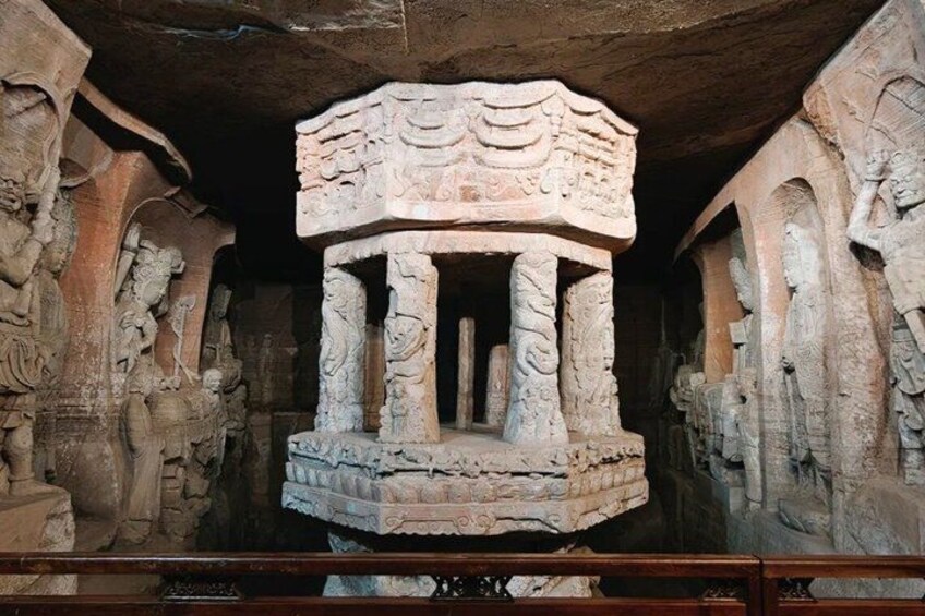 A stone structure with intricate carvings, columns, and a central platform. 2