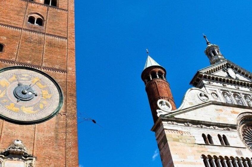 A clock tower with a large circular dial and a smaller clock on a brick building. 3