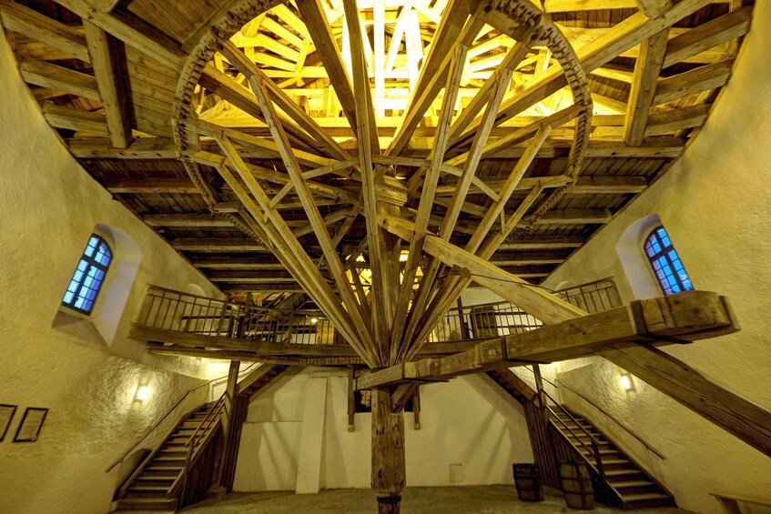 A wooden structure with a central wheel and multiple staircases. 3
