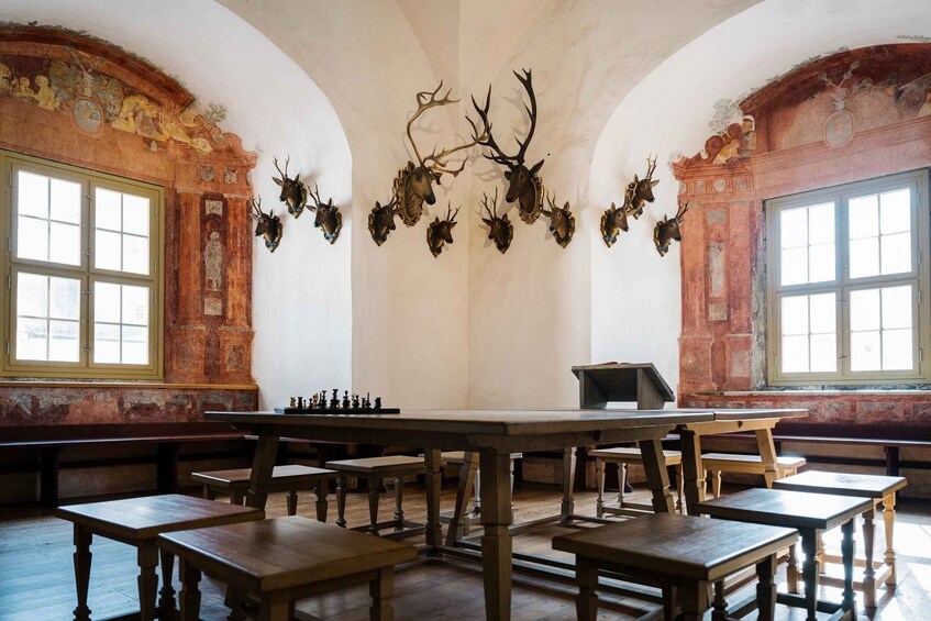 A room with a large table, chairs, and a chessboard. 4