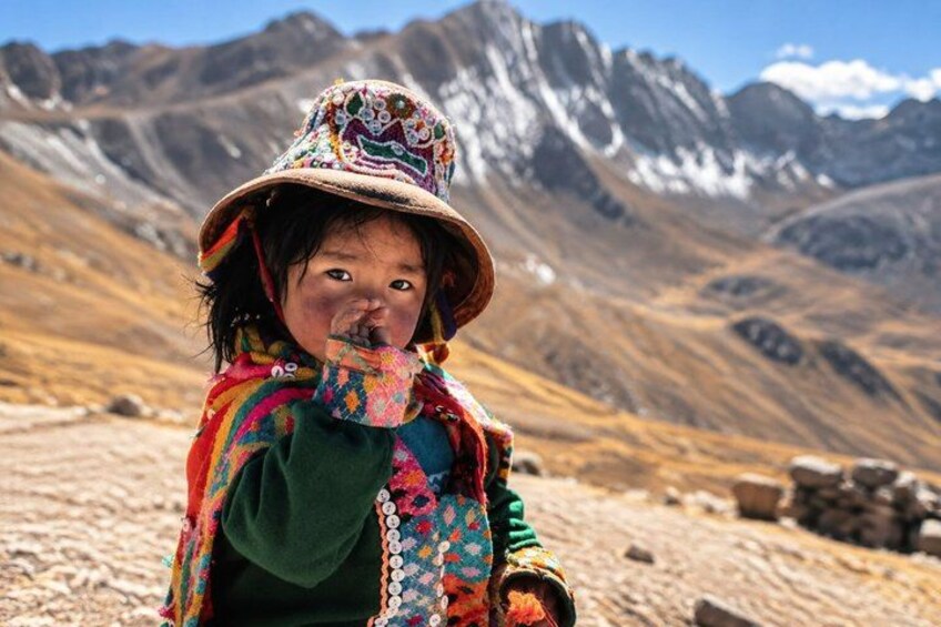 A person in colorful traditional attire with a mountainous landscape in the background. 4