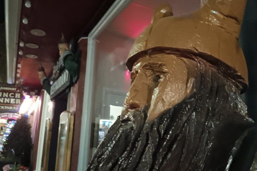 A wooden sculpture of a lion's head with a textured mane. 2