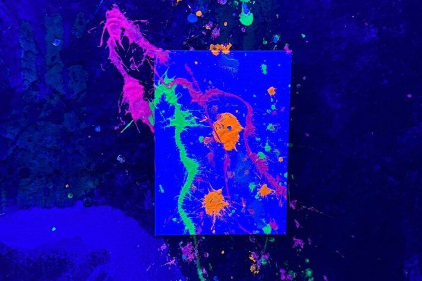 A vibrant abstract painting with splashes of pink, green, and orange on a dark background. 4