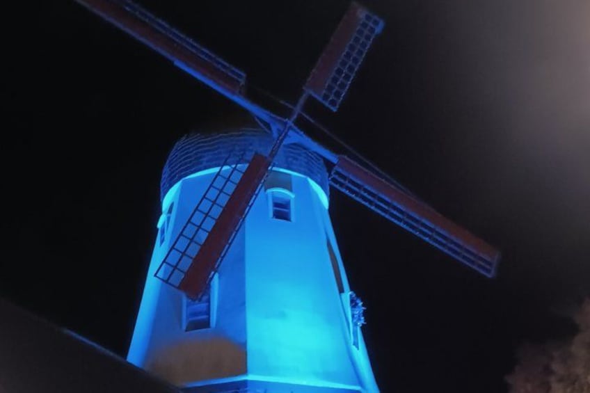 A windmill with a lit top and a ladder. 2