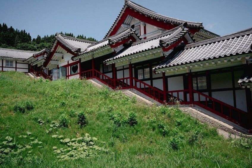 Traditional Korean architecture with curved roofs and red accents. 2