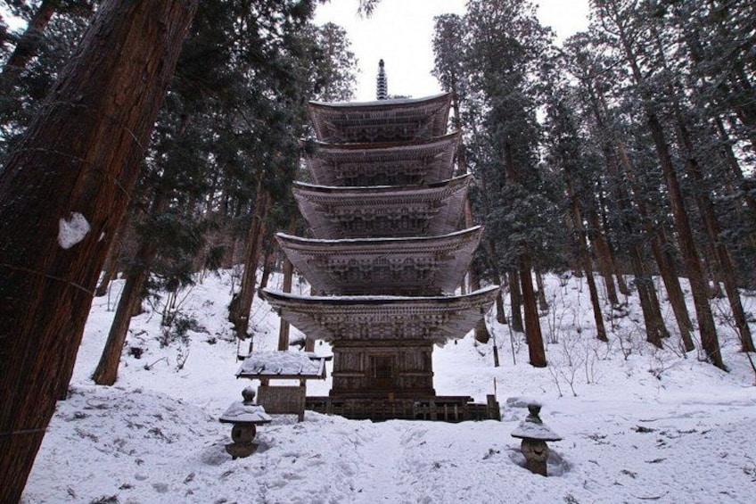 A traditional multi-tiered pagoda in a snowy forest. 5