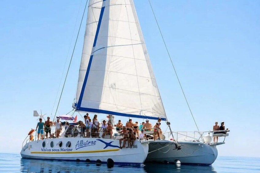 A sailboat named 'Albatros' with passengers on deck, sailing on calm waters. 5