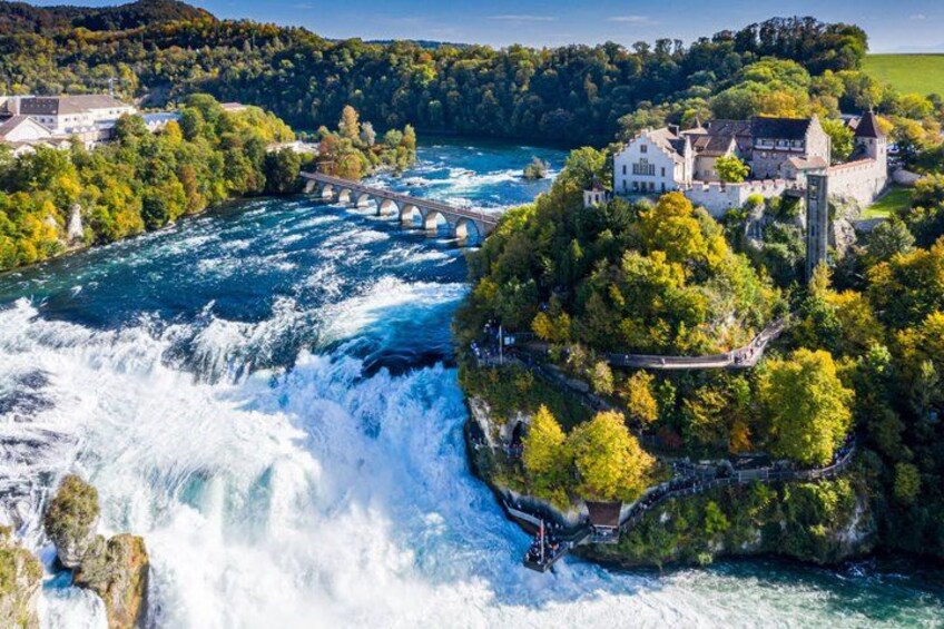A river with a waterfall, a bridge, and a castle on a hill. 1