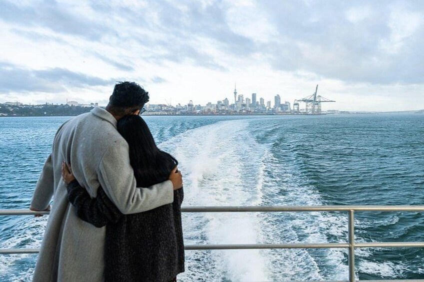 A couple embracing on a boat with a city skyline in the background. 4