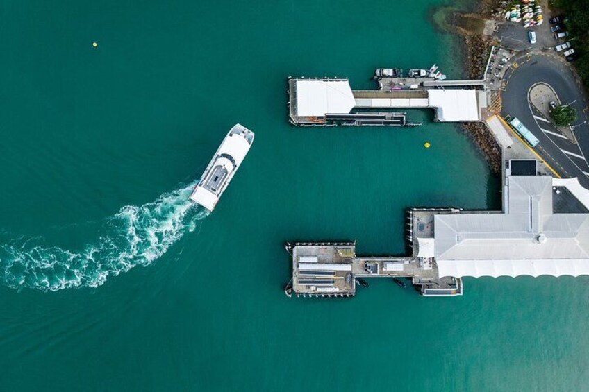 A boat moving away from a dock, a pier, and a building. 3