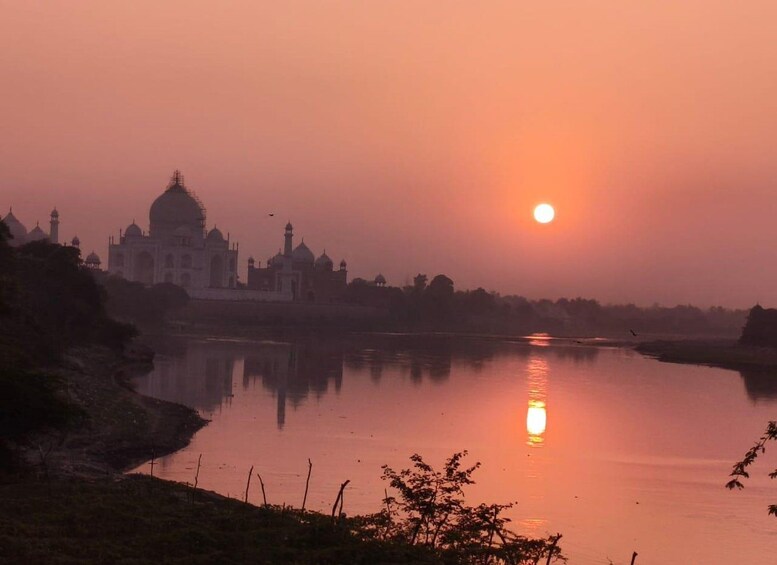 Der Taj Mahal im Morgengrauen, die Sonne spiegelt sich im Wasser. 4